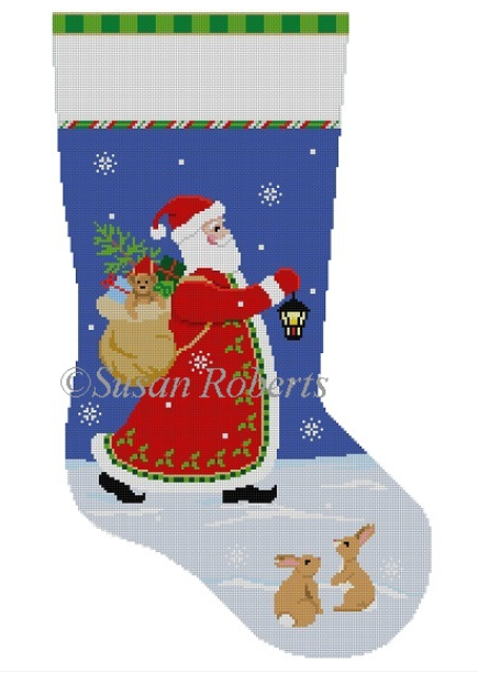 Susan Roberts Christmas stocking needlepoint canvas of Santa walking with his bag of toys at night in the snow with a lantern with two bunny rabbits in the foreground