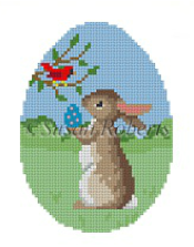 Susan Roberts Easter egg shaped needlepoint canvas of a bunny rabbit offering an egg to a cardinal bird in a tree