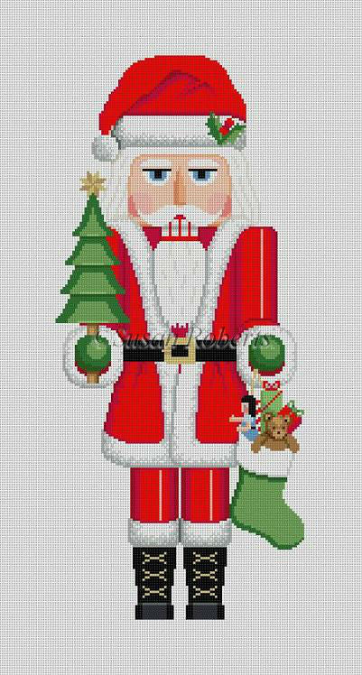Susan Roberts Christmas needlepoint canvas of a nutcracker of Santa Claus holding a small Christmas tree and a stocking full of toys. Santa is dressed in traditional red