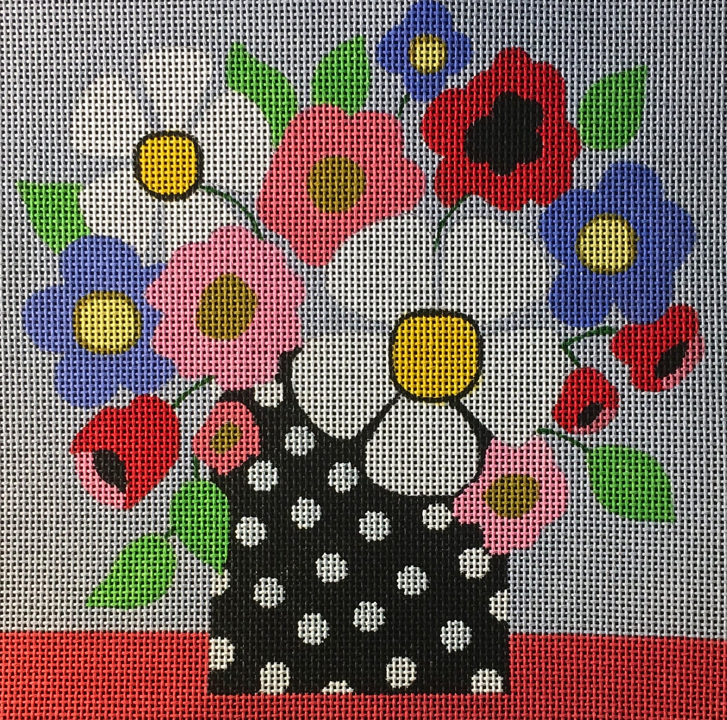 Amanda Lawford bright needlepoint canvas of a mod polka dot vase with daisies, poppies, and other flowers