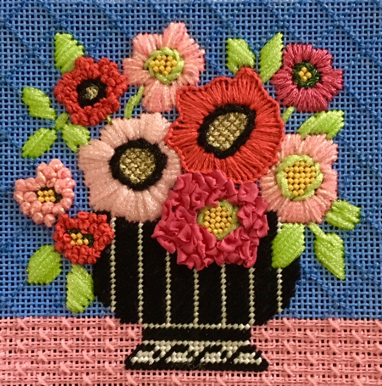 Stitched example of the pink mod flowers coaster needlepoint canvas from Amanda Lawford and Vallerie Needlepoint Gallery