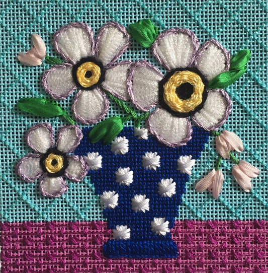Stitched example of the Amanda Lawford white mod flowers coaster needlepoint canvas with a turquoise background and a blue and white polka dot vase