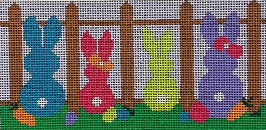 Vallerie Needlepoint Gallery whimsical easter needlepoint canvas of four bunnies sitting at a picket fence with white tails next to carrots and eggs in vibrant spring colors