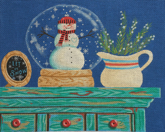Kim Leo for Vallerie Needlepoint Gallery needlepoint canvas of a snowman snow globe on a dresser with a pitcher of flowers and a sign saying "let it snow"