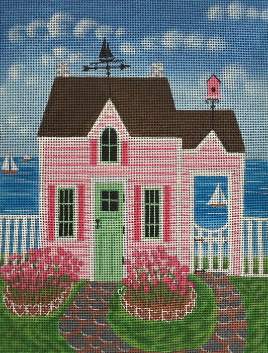 Kim Leo needlepoint canvas of a pink cottage by the sea with sailboats in the background