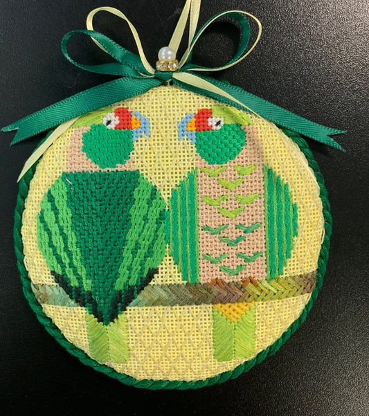 Scott Partridge round needlepoint canvas of two tropical geometric and stylized green parrots sitting on a wire