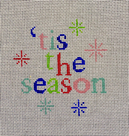 Vallerie Needlepoint Gallery bright winter and Christmas round needlepoint canvas of the phrase "tis the season" with snowflakes in vibrant colors