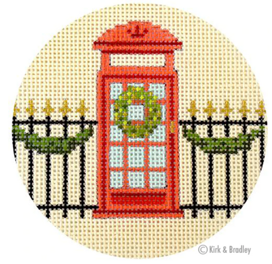 Kirk and Bradley ornament-sized needlepoint canvas of a London red telephone box with a wreath and a fence with Christmas garland. Part of a series of London Christmas scenes