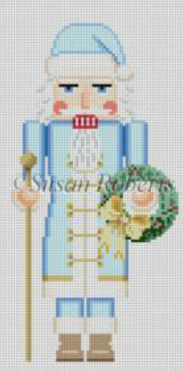 Susan Roberts needlepoint canvas of a Santa nutcracker wearing blue with a staff and a wreath