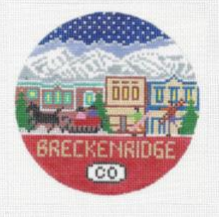 Round needlepoint canvas of Breckenridge Colorado with landscape in background of town and snowy mountains