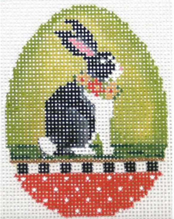 Kelly Clark Easter egg needlepoint canvas of a large black and white bunny rabbit with a floral collar on a bright green background with polka dot border