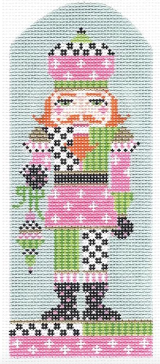 Kelly Clark needlepoint canvas of a preppy nutcracker with pink and green geometric patterns holding a Christmas ornament