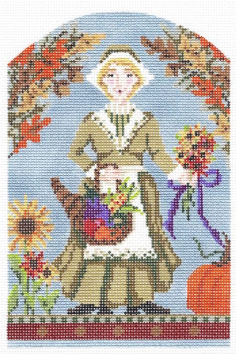 Kelly Clark Thanksgiving needlepoint canvas of a female pilgrim holding a cornucopia and flowers with fall foliage 